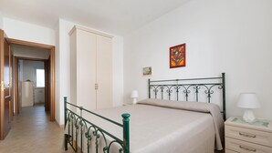 A bedroom with a bed, a nightstand, a dresser, a wardrobe, and a painting on the wall. - 3223 La Casa di Roberta by Barbarhouse (Otranto)