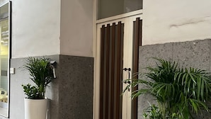 Una entrada de edificio con una planta grande a la izquierda y otra a la derecha.