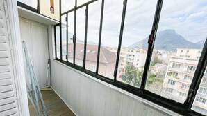 A narrow corridor with a large window overlooking a cityscape and a mountain. - #FF | Pretty light in Grenoble ☀ | T2 (Grenoble)