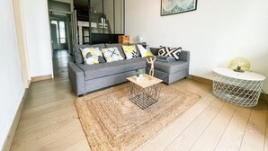A modern living room with a grey sofa, patterned cushions, a wooden coffee table, a woven rug, and a globe artwork on the wall. - #FF | Pretty light in Grenoble ☀ | T2 (Grenoble)