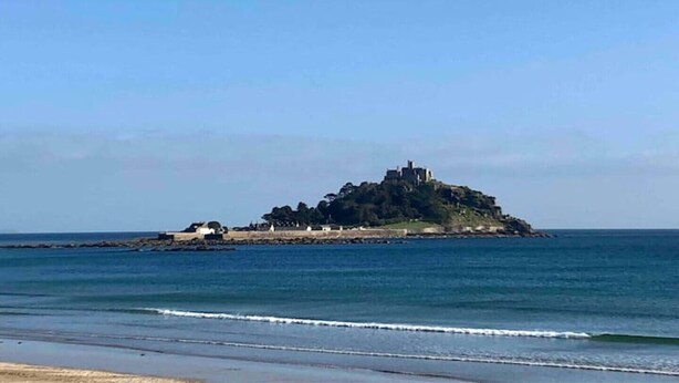 Vista costera con una pequeña isla que presenta una estructura similar a un castillo.