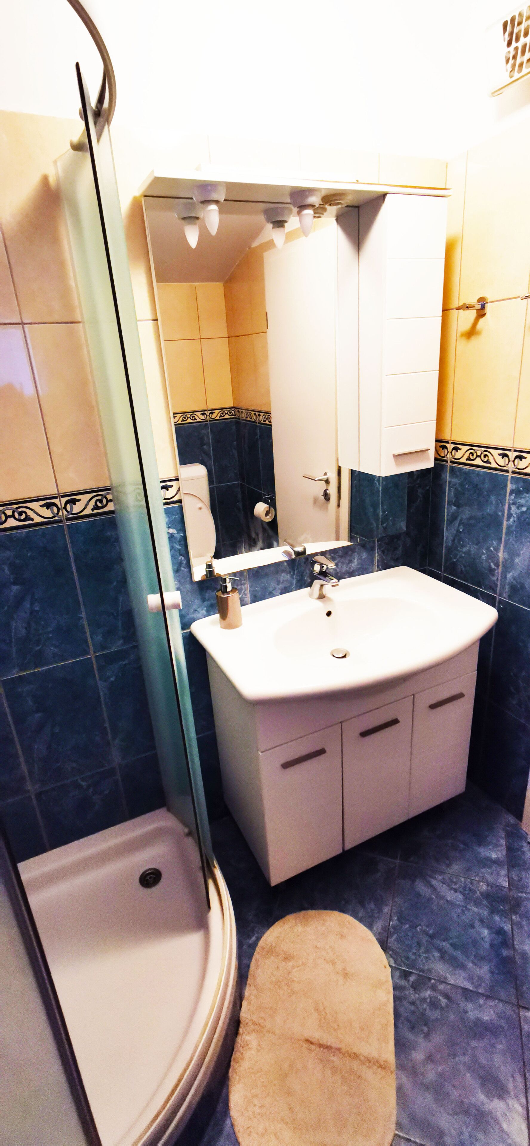 A bathroom with a white sink, a mirror, and a shower.