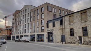 Un edificio de varios pisos con un diseño moderno, que combina fachadas de ladrillo y cristal.