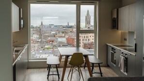 Una cocina moderna con un amplio ventanal, una mesa de comedor y taburetes de bar.