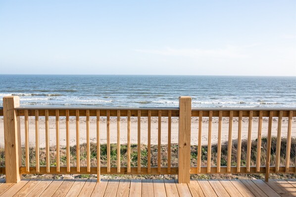 A wooden deck with a view of the ocean.