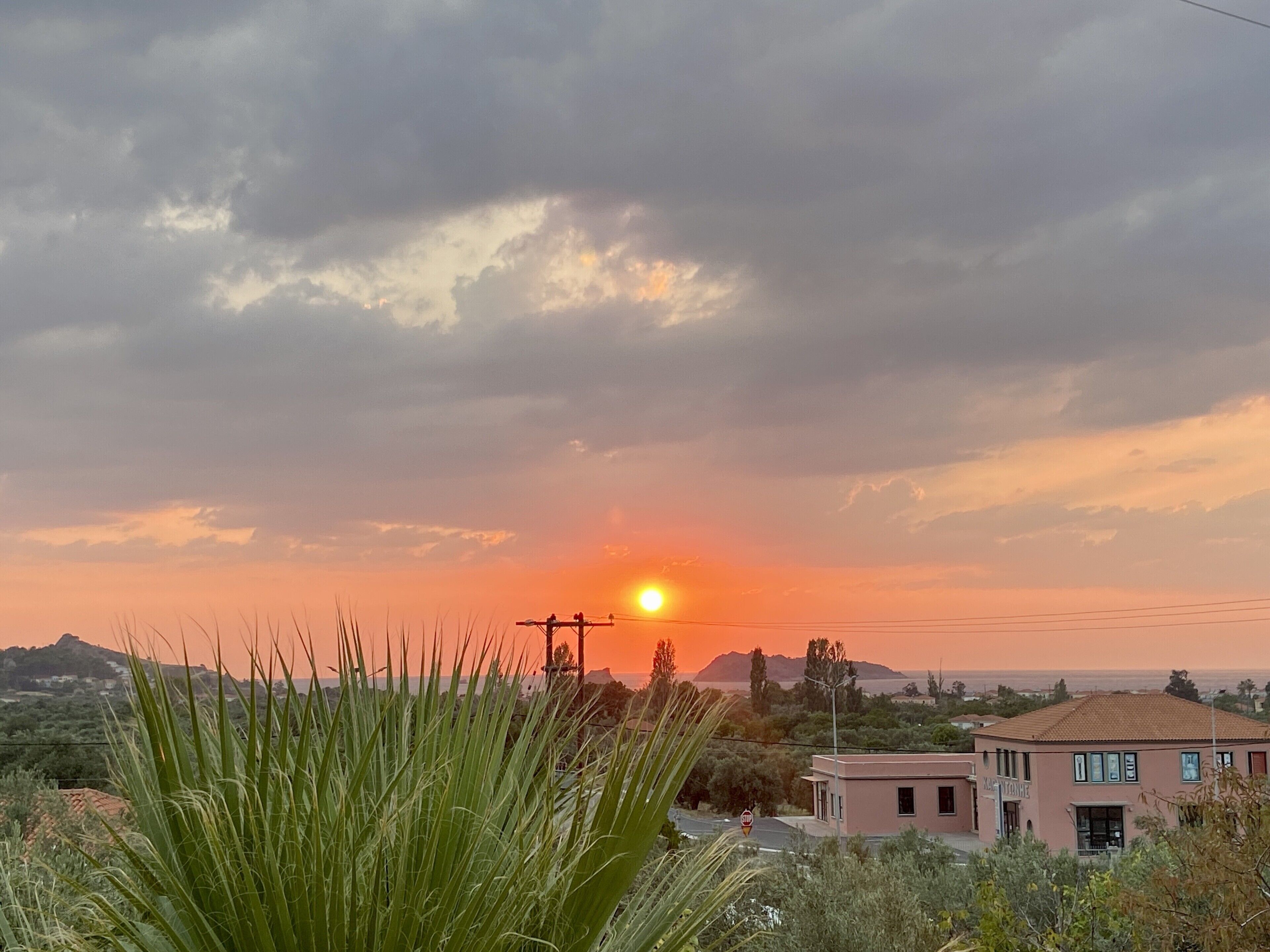 A sunset over a residential area with a building in the foreground.