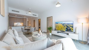 Un salon moderne comprenant un canapé, une table basse, un téléviseur et un coin repas.