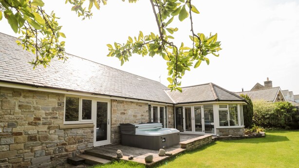 A stone house with a hot tub and a covered patio area. - The Croft (Alnwick)