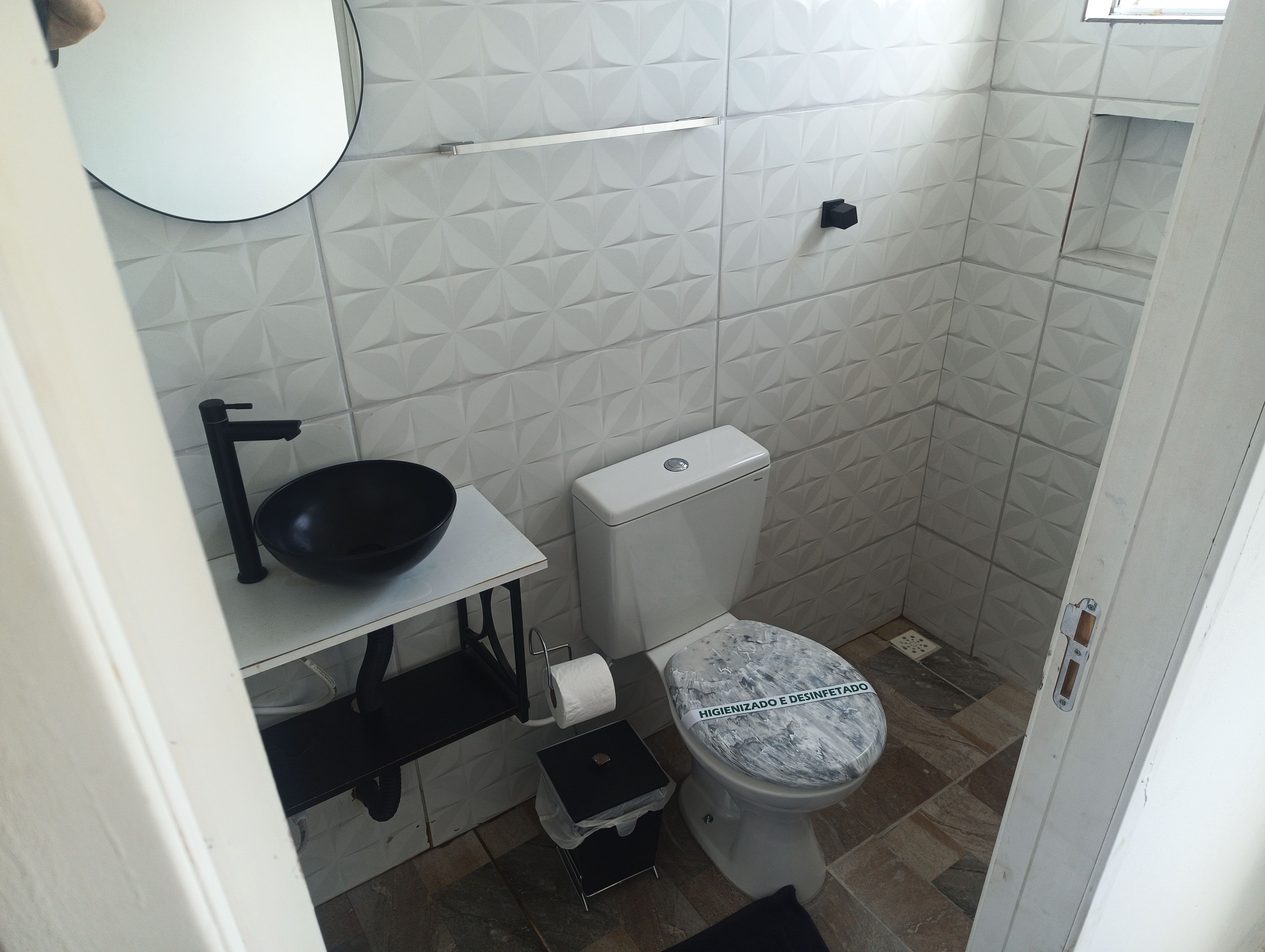 Une petite salle de bain avec des toilettes, un lavabo et un miroir.