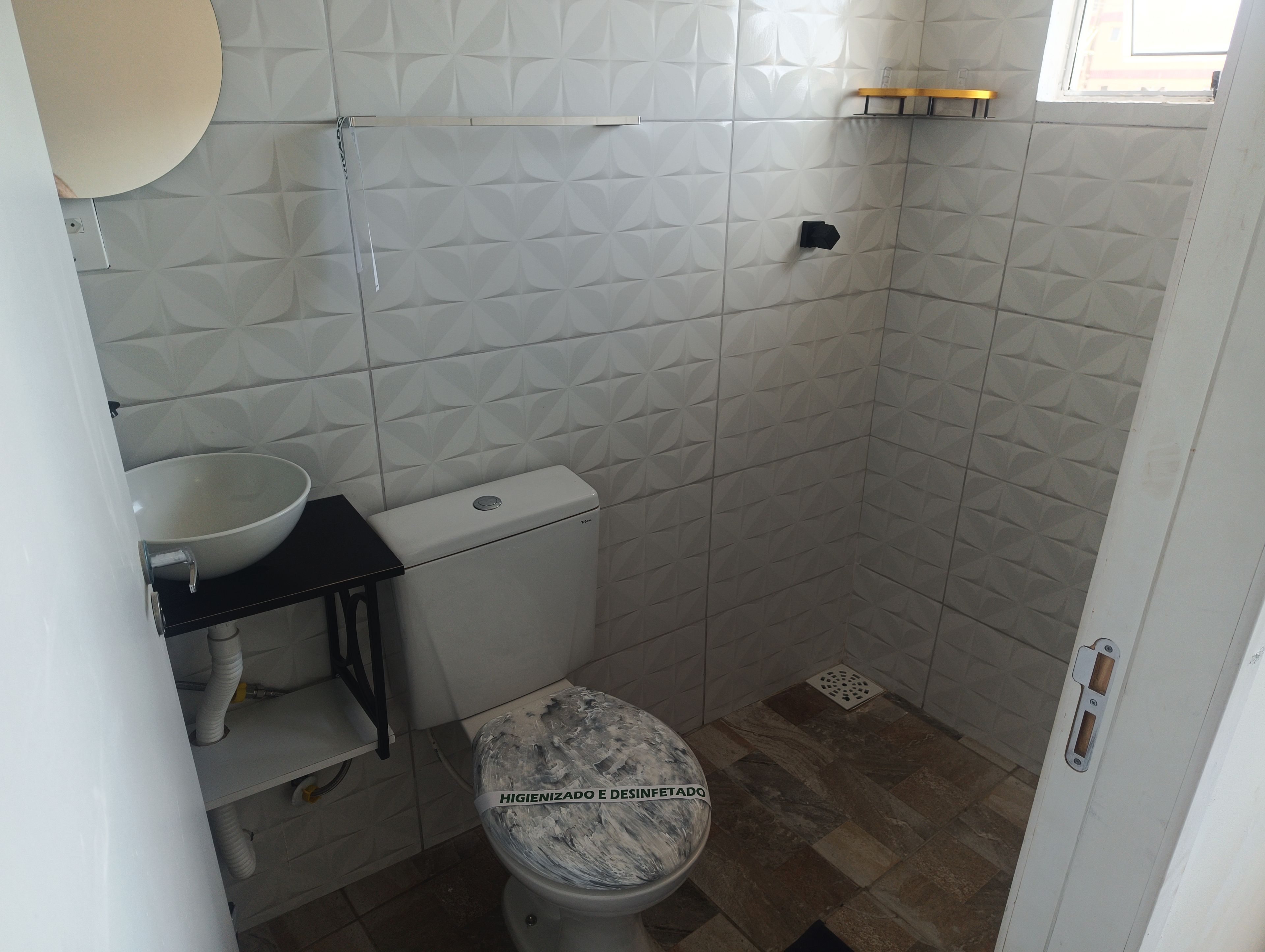 A bathroom with a toilet, sink, and a shower area.