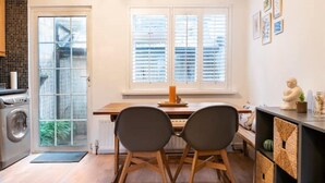 Une cuisine compacte comprenant un coin repas, un lave-linge et un radiateur.
