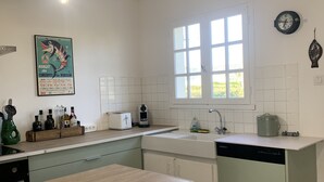 Een keuken met een houten aanrecht, een spoelbak, een vaatwasser en een raam.