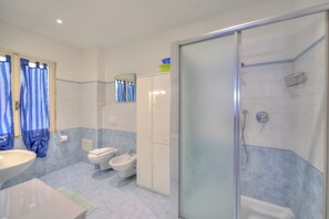 Un bagno moderno con doccia, toilette, bidet e lavandino.