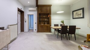 Ein moderner Essbereich mit Holztisch und Stühlen, eine Küche mit integriertem Schrank und ein gerahmtes Bild an der Wand.