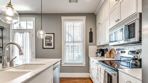 A modern kitchen with white cabinets, a stainless steel range, and a Bosch microwave. - Carlton Landing-Goose Bay (Carlton Landing)