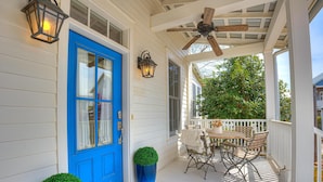 A porch with a blue door, a ceiling fan, and a table with chairs. - Carlton Landing-Goose Bay (Carlton Landing)