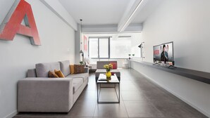 Una sala de estar moderna con un sofá, una mesa de centro y una televisión en la pared.