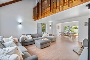 Relax in this stylish living area with a large sofa, ottoman, and wooden coffee table.