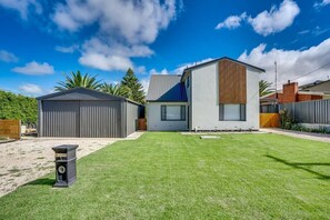 Enjoy a home with a well-maintained lawn and a two-story house featuring a garage and covered outdoor area.