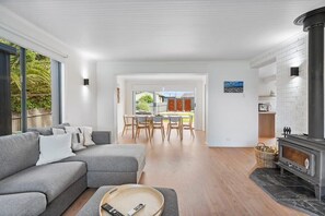 Relax in this inviting space with a sofa, dining area, and glass door leading to the outdoors.
