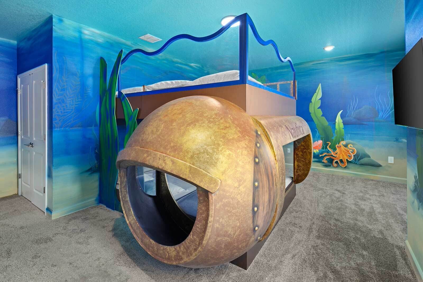 A play area with a large, cylindrical tunnel structure and a mural of an underwater scene.