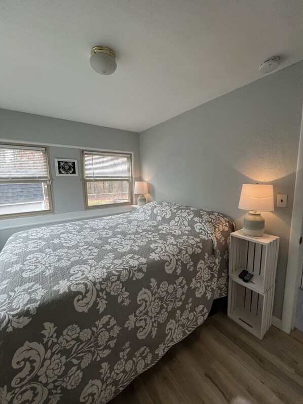 Une chambre à coucher avec un grand lit, deux lampes de chevet et une petite table de nuit.
