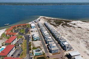 Een kusthotel met meerdere gebouwen, een parkeerplaats en een strandgedeelte.