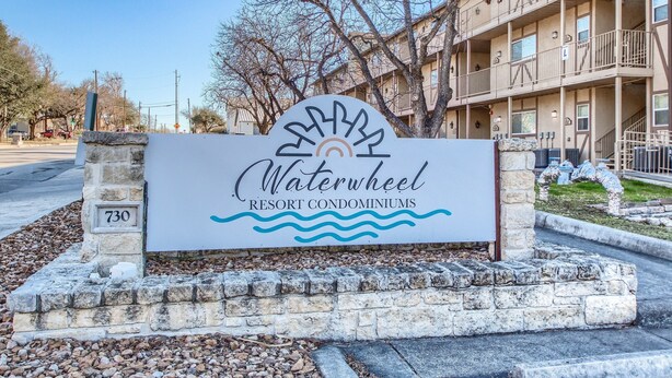 Schild für das Waterwheel Resort Condominiums mit Steinsockel und blauem Himmel im Hintergrund.
