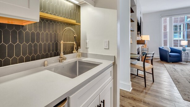 A modern kitchen with a large sink, a gold faucet, and a hexagonal tile backsplash. - Unbeatable Location in Heart of Historic Savannah by Lucky Savannah (Savannah)