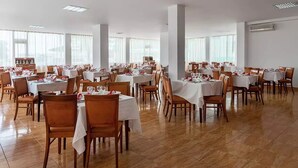 A spacious dining area with multiple tables and chairs, arranged in rows. - Hotel Balada (Saturn)