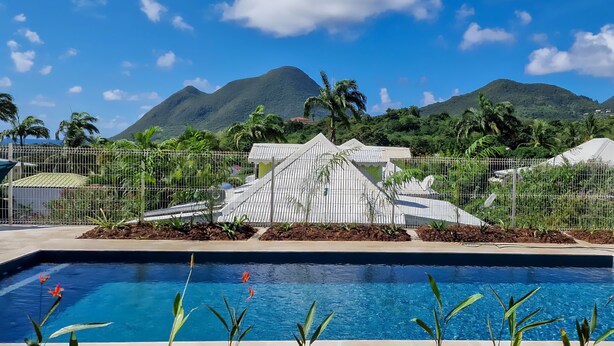 Una piscina con vistas a montañas y una estructura tipo invernadero.