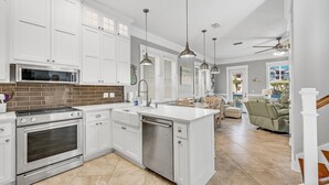 A modern kitchen with white cabinetry, stainless steel appliances, and a central island.