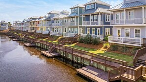 A row of waterfront houses with wooden decks and railings.