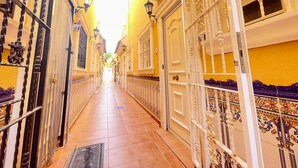 A narrow corridor with ornate doors and railings, leading to a bright interior. - Pleasant 4 Bedroom Townhouse with Com Pool VM7 (Orihuela)