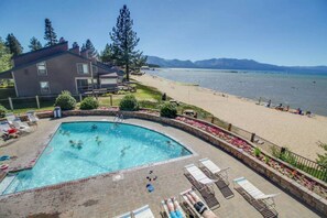 Zona de piscina con vista a la playa y las montañas.