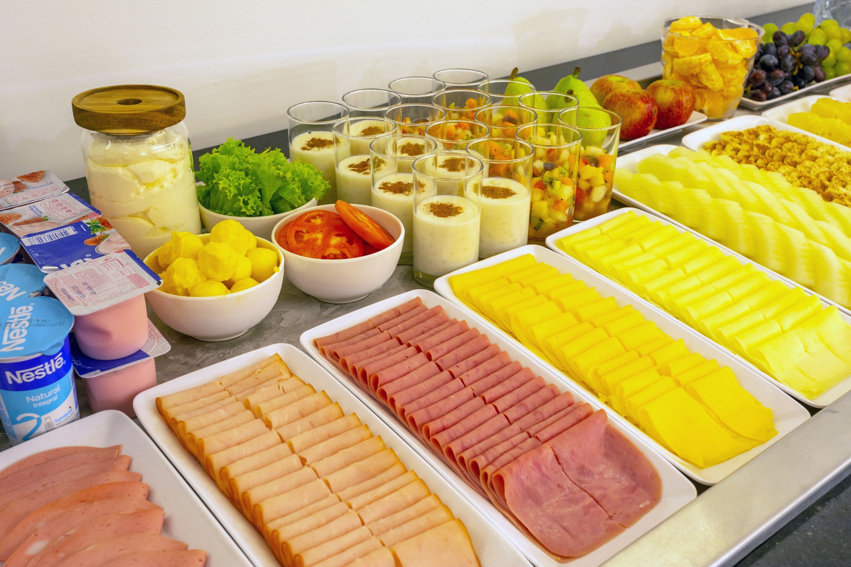 Un buffet con diverse pietanze tra cui salumi, frutta e latticini.