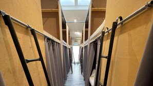 A corridor with bunk beds, wooden walls, and a skylight. - The Old Factory - Hostel (Copenhagen)