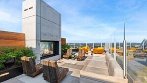 A rooftop terrace with modern seating, a fire feature, and a view of the cityscape. - 20th FL 1BR / Heated Pool / Gym / Bar (Austin)