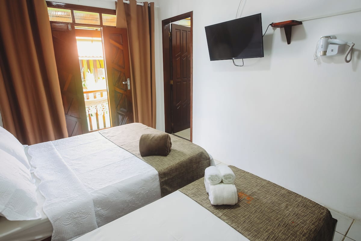 Una habitación de hotel con una cama, una mesita, un televisor y un teléfono.