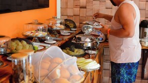Ein reichhaltiges Buffet mit verschiedenen Speisen und einer Person, die diese serviert.