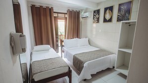 Ein Hotelzimmer mit zwei Betten, einem Kleiderschrank und einem Fenster mit Vorhängen.