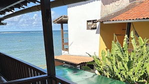 Ein Balkon mit Meerblick, eine Holzterrasse und ein kleiner Gartenbereich mit Pflanzen.