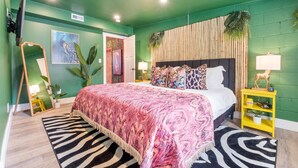Un dormitorio con cama, espejo, planta, estante y puerta.
