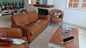A living room with a brown leather sofa, a wooden coffee table, and a patterned ceiling light. - 12 km St Gilles Croix de Vie to Coex. Sea, Golf, 3 lakes. 25 km Sables d'olonne  (Coëx)
