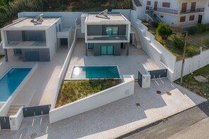 A modern multi-story residential building with a rooftop pool and a landscaped garden area. - Villa Foz - Holiday Villa with Private Pool By SCH (Foz do Arelho)