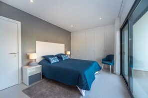 A modern bedroom with a large bed, bedside tables, a chair, and a wardrobe. - Villa Foz - Holiday Villa with Private Pool By SCH (Foz do Arelho)