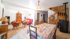 Un salón amplio con una cama grande, muebles de madera, una escalera y un televisor.