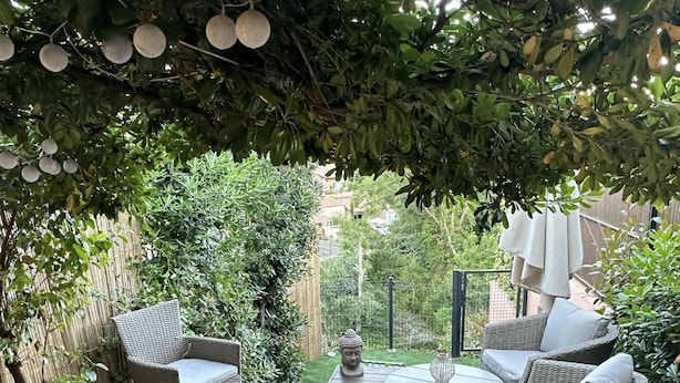 A wooden deck with wicker furniture, a Buddha statue, and a garden view. - La Pélagie - Maison 6 personnes (Sainte-Maxime)