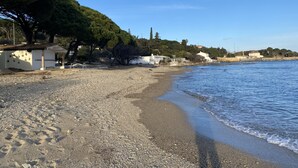 A pebble beach with a white building and trees. - La Pélagie - Maison 6 personnes (Sainte-Maxime)