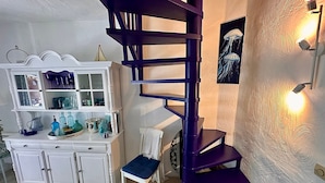 A modern interior with a white cabinet, a purple spiral staircase, and a wall-mounted light fixture. - La Pélagie - Maison 6 personnes (Sainte-Maxime)